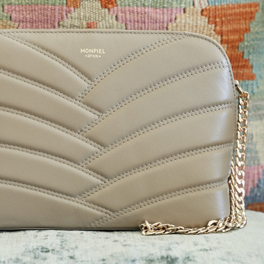 Sac matelassé en cuir couleur cuir avec chaîne dorée, à côté de savons - MONPIEL 2