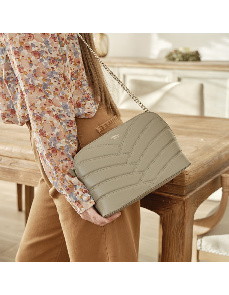 Borsa in pelle trapuntata con catena dorata color topo appesa sulla spalla di profilo con vista frontale della borsa - MONPIEL Borsa in pelle trapuntata con catena dorata color topo appesa sulla spalla di profilo con vista frontale della borsa - MONPIEL