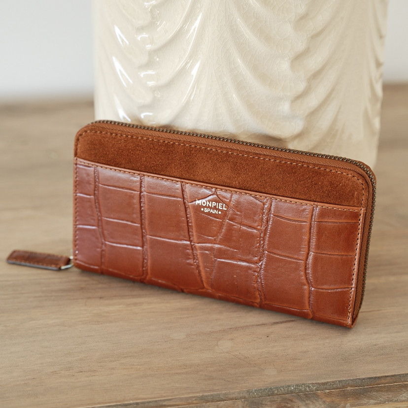 Women's leather zipper wallet in tan, shown in perspective resting on a vase - MONPIEL