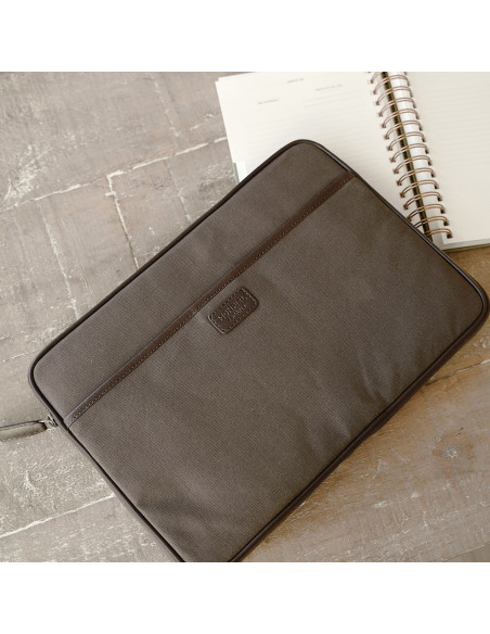 13" and 14"-inch green leather sport laptop sleeve, shown from the front on a wooden table - MONPIEL