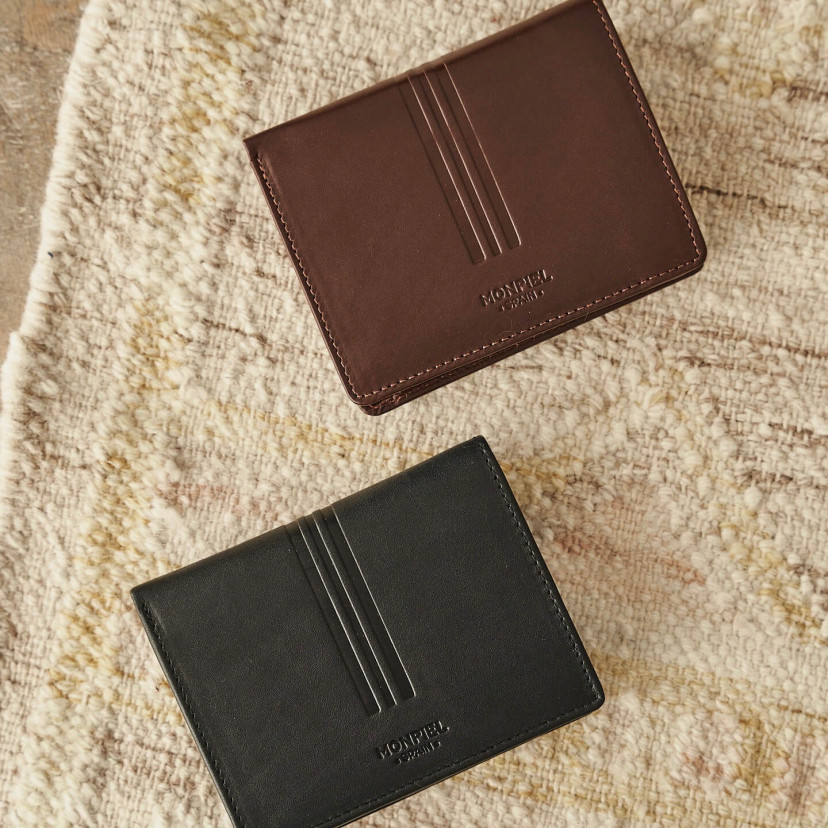 Leather wallet with coin purse in black and brown, shown from the front on a carpet - MONPIEL