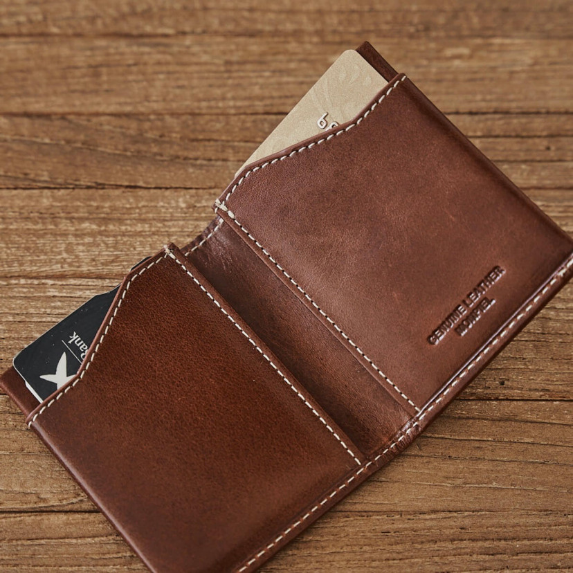 Tan leather pocket wallet, open on a wooden table - MONPIEL