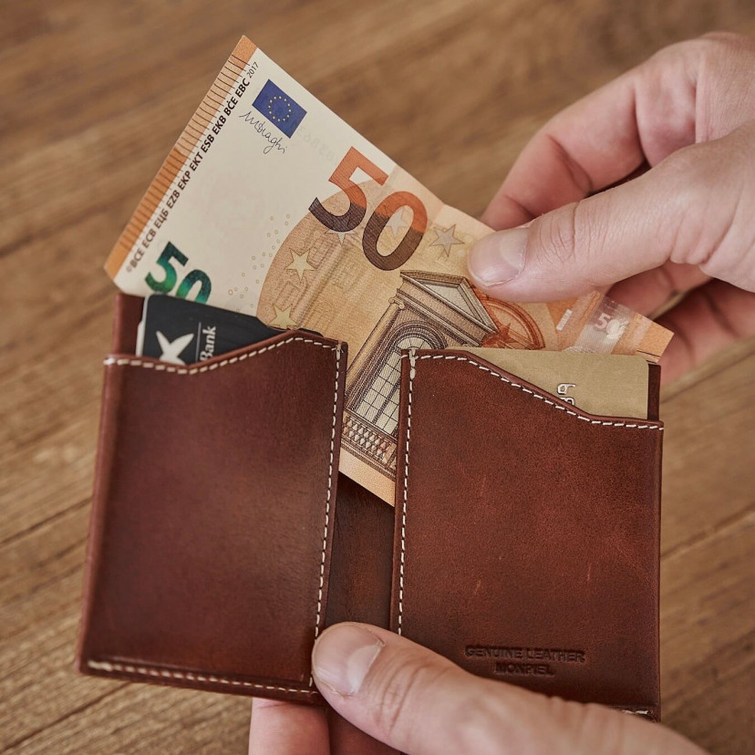 Tan leather pocket wallet, open in hands with bill detail - MONPIEL