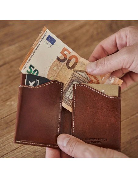 Portefeuille pocket en cuir couleur cuir, ouvert dans les mains avec détail du billet - MONPIEL