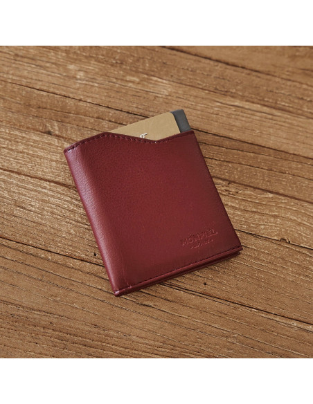 Burgundy leather pocket wallet, shown from the front and slightly tilted on a wooden table - MONPIEL Burgundy leather pocket wallet, shown from the front and slightly tilted on a wooden table - MONPIEL