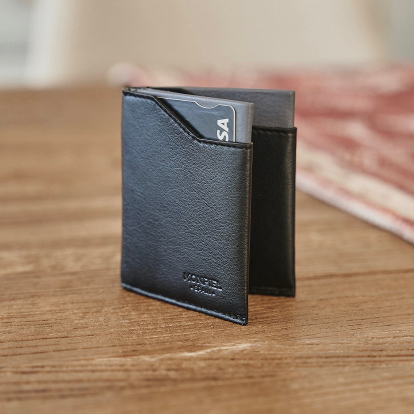 Black leather pocket wallet, semi-open and resting vertically on a wooden table - MONPIEL