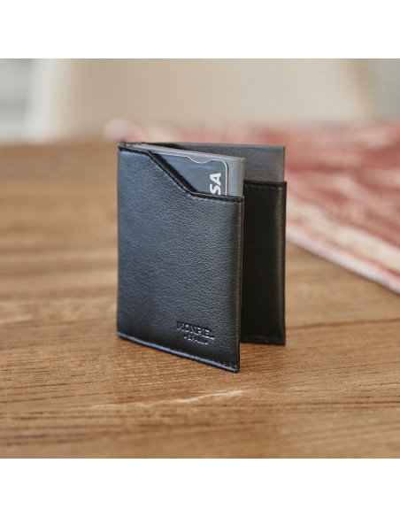 Cartera pocket de piel en color negro semi abierta apoyada en vertical sobre una mesa de madera - MONPIEL Cartera pocket de piel en color negro semi abierta apoyada en vertical sobre una mesa de madera - MONPIEL