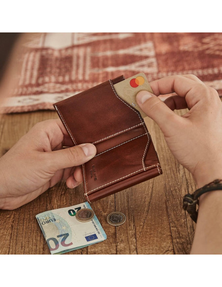 Pocket wallet with coin pocket in leather color, showing detail of inserting a card into the slot - MONPIEL Pocket wallet with coin pocket in leather color, showing detail of inserting a card into the slot - MONPIEL