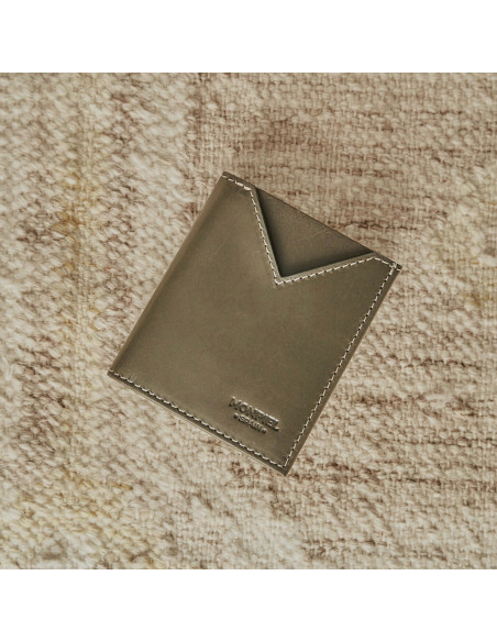 Petit portefeuille homme en cuir vert, vue de face reposant sur un tapis - MONPIEL