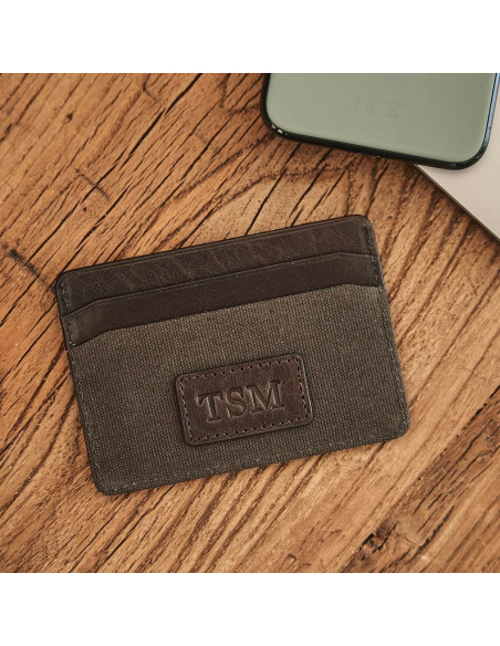 Green sport leather cardholder, shown from the front with personalized detail on a wooden table - MONPIEL Green sport leather cardholder, shown from the front with personalized detail on a wooden table - MONPIEL
