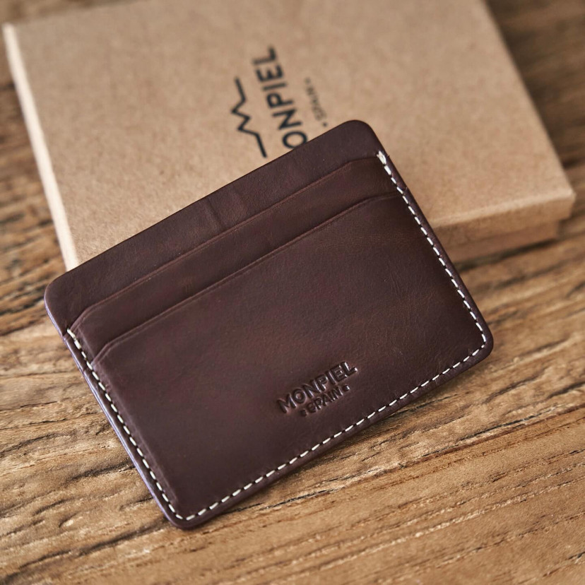Mini brown leather cardholder with logo detail, shown from the front resting on its box - MONPIEL