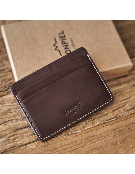 Mini brown leather cardholder with logo detail, shown from the front resting on its box - MONPIEL Mini brown leather cardholder with logo detail, shown from the front resting on its box - MONPIEL