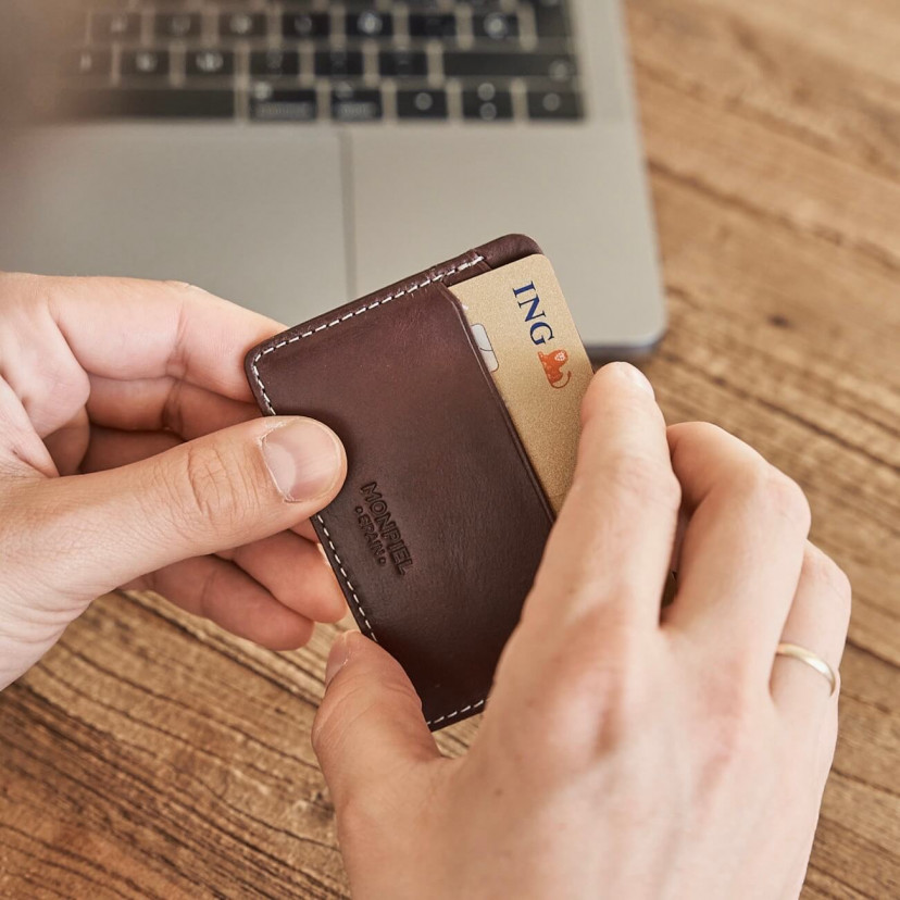 Mini brown leather cardholder, held in hands with card detail - MONPIEL
