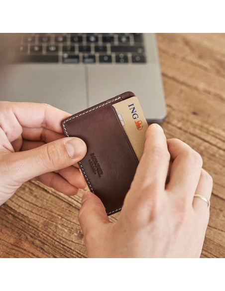 Portacarte mini in pelle marrone, tenuto nelle mani, con dettaglio della carta - MONPIEL