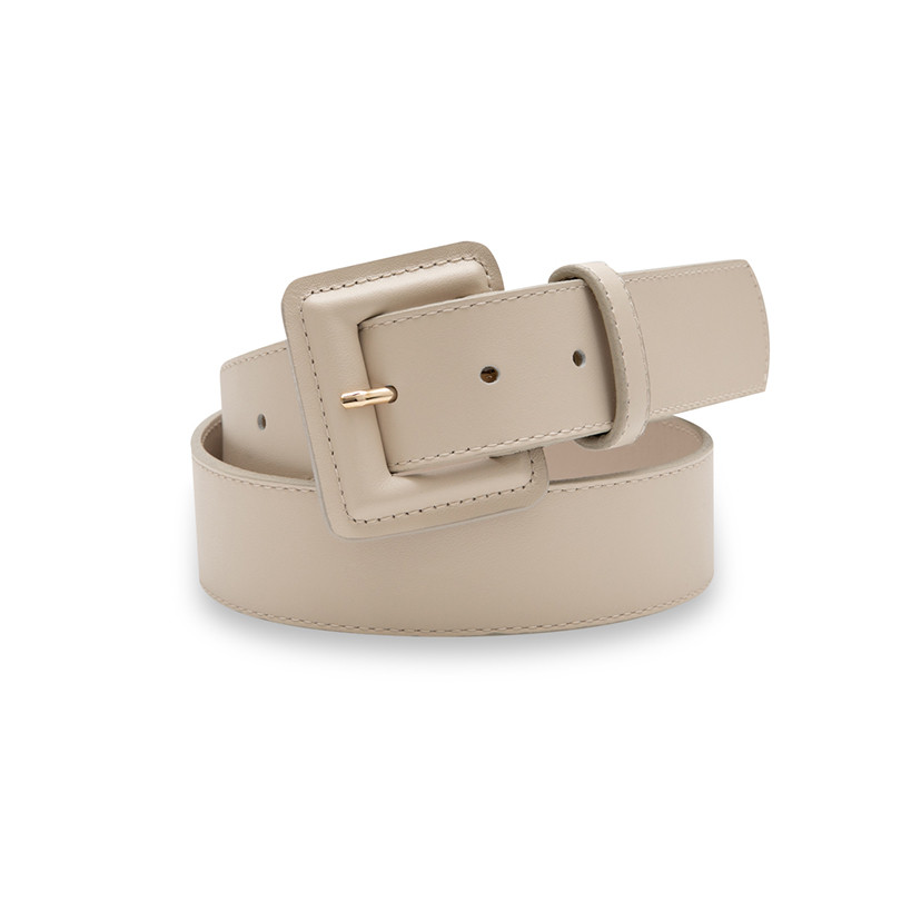 Wide women's leather belt with covered buckle in beige, coiled on a white background - MONPIEL