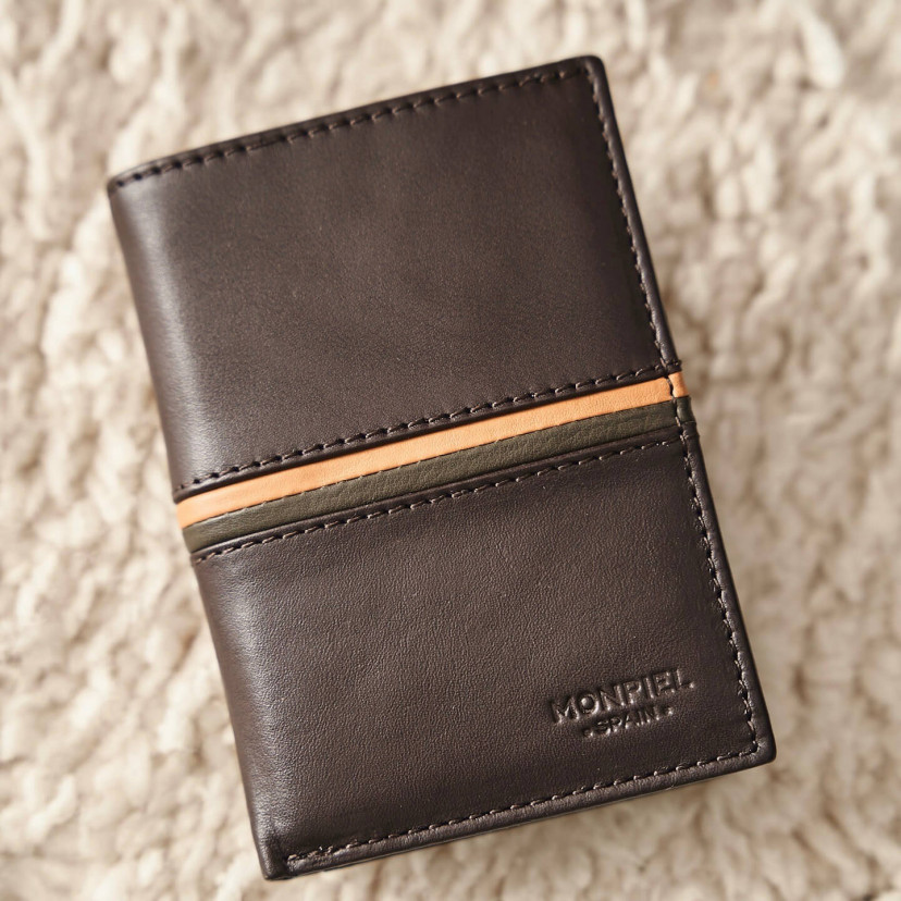 Leather wallet with coin purse inside, striped in brown color, shown from the front and slightly tilted on a carpet - MONPIEL