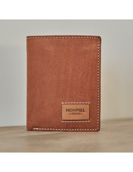 Simple leather wallet with logo in Havana color, front view, on a wooden table - MONPIEL