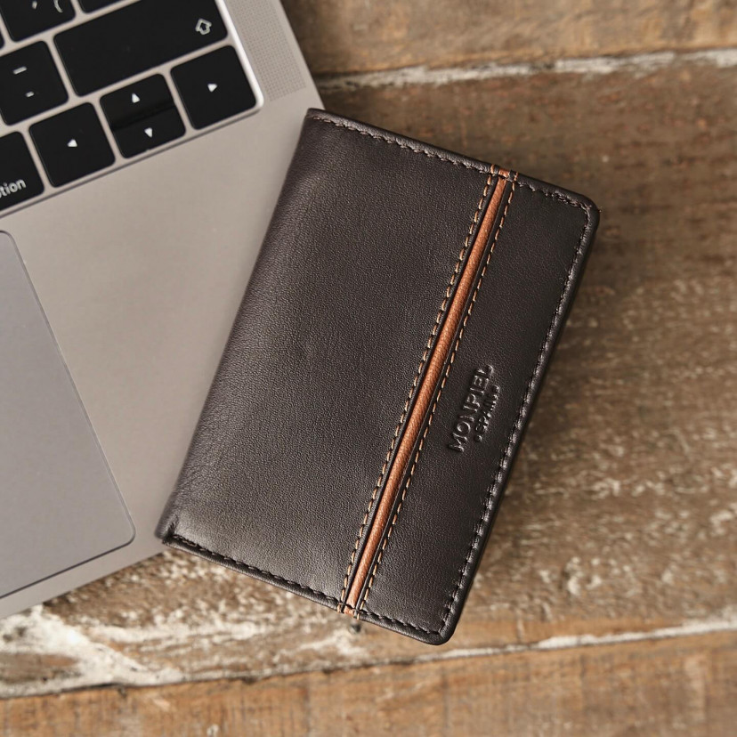 Leather wallet with lateral stripe and coin pocket in brown color, front view, resting on a laptop - MONPIEL