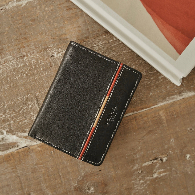 Leather purse with coin pocket, featuring Spanish flag, in black color, front view, on a wooden table - MONPIEL