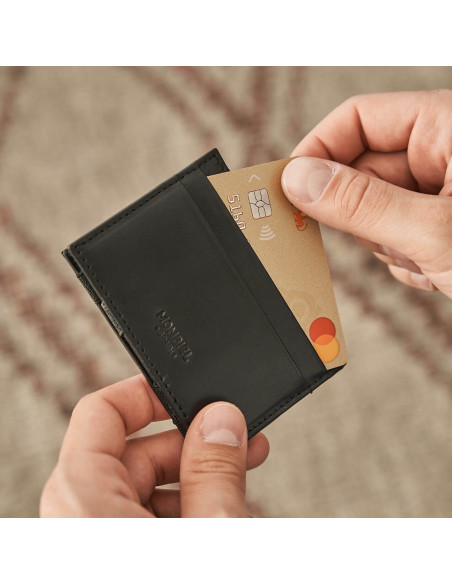 Magical leather cardholder in black, showing card slots on a wooden table - MONPIEL
