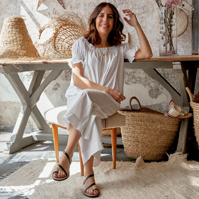 Milos leather strappy sandal in tan color, legs crossed, full view - MONPIEL