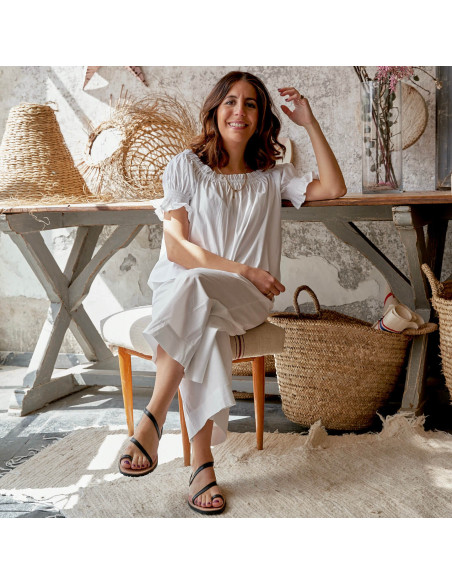 Milos leather strap sandal in leather color, legs crossed, wide shot - MONPIEL