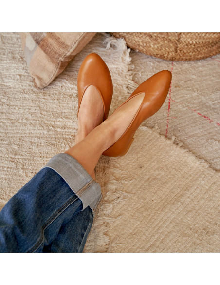 Flat ballerina in tan color, feet crossed and resting on a rug - MONPIEL Flat ballerina in tan color, feet crossed and resting on a rug - MONPIEL