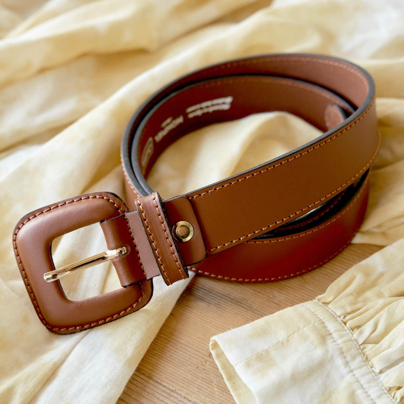 Women's leather belt with covered buckle in brown color, coiled on a dress - MONPIEL