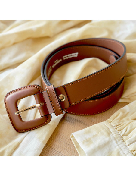 Women’s leather belt with covered buckle in brown, coiled on a dress - MONPIEL Women’s leather belt with covered buckle in brown, coiled on a dress - MONPIEL