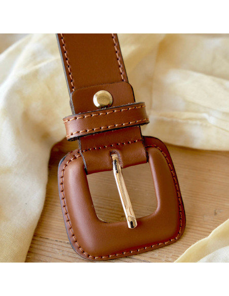 Women’s leather belt with covered buckle in brown, close-up detail of the buckle - MONPIEL Women’s leather belt with covered buckle in brown, close-up detail of the buckle - MONPIEL