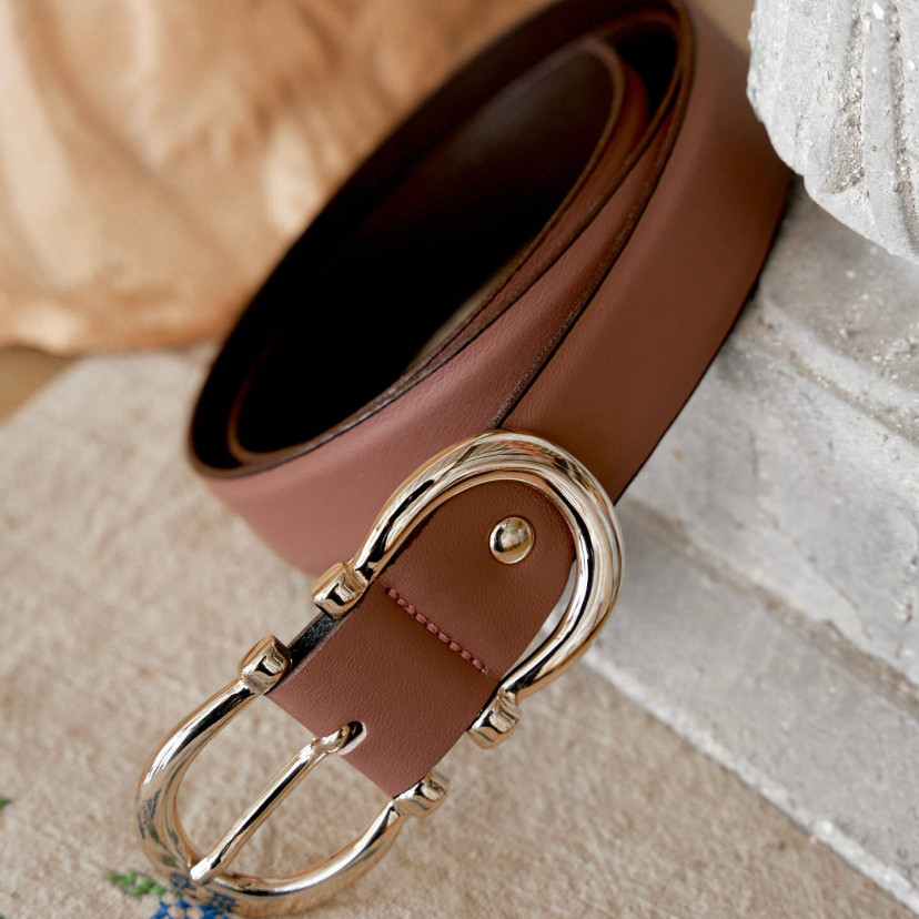 Women’s double buckle leather belt in pink blush color, coiled, buckle in close-up - MONPIEL