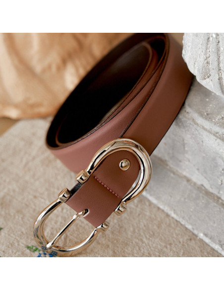 Women’s double buckle leather belt in rose pink, coiled with buckle in foreground - MONPIEL