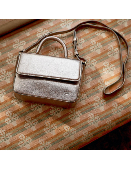 Petit sac en cuir métallisé champagne Armado, vue de dessus et frontale, posé sur un canapé - MONPIEL