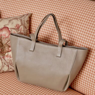 Bolso canasto piel en color topo apoyado en el sofa con vista frontal - MONPIEL