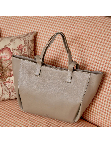 Bolso canasto piel en color topo apoyado en el sofa con vista frontal - MONPIEL