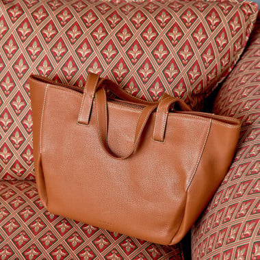 Borsa a cesta in pelle color cuoio con vista frontale appoggiata su una sedia di legno - MONPIEL 2