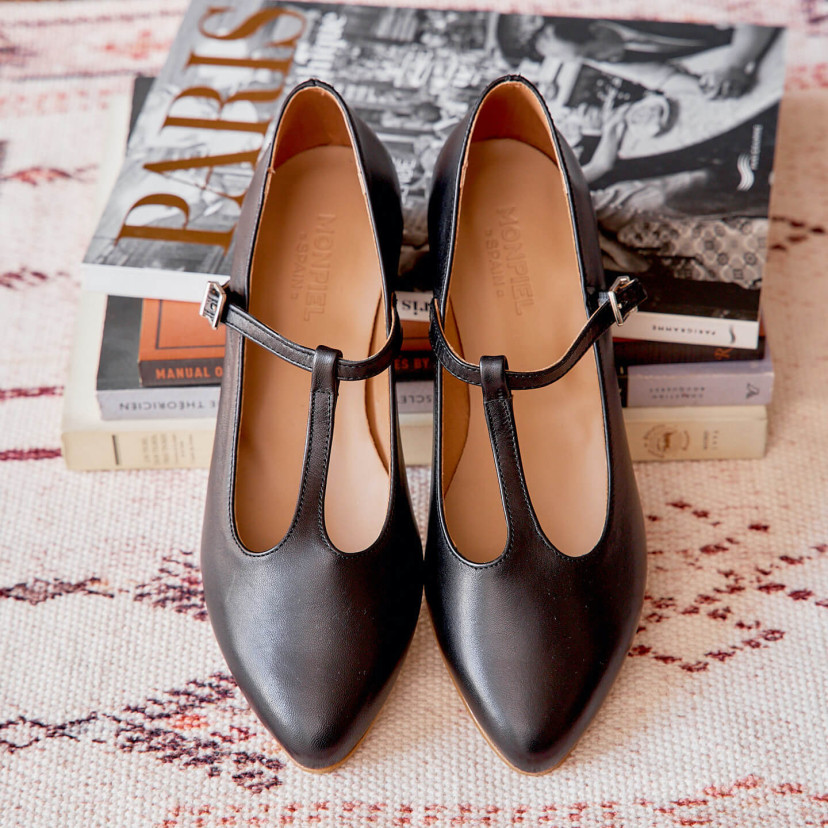 Marieta leather Mary Janes for women in black color, front view, heel resting on books - MONPIEL