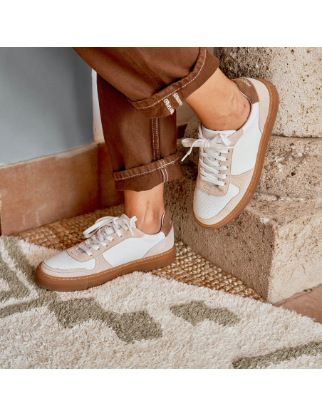 Baskets en cuir Cosmo blanches, vue en perspective avec un pied posé sur une colonne - MONPIEL Baskets en cuir Cosmo blanches, vue en perspective avec un pied posé sur une colonne - MONPIEL