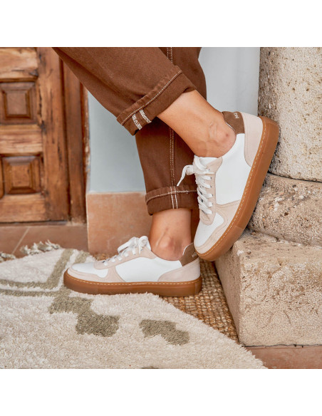 Sneakers piel cosmo en color blanco con vista de perfil y pie apoyado en columna - MONPIEL Sneakers piel cosmo en color blanco con vista de perfil y pie apoyado en columna - MONPIEL