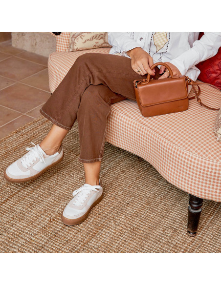 Tênis de couro Cosmo em branco, plano médio com detalhe da bolsa no sofá - MONPIEL Tênis de couro Cosmo em branco, plano médio com detalhe da bolsa no sofá - MONPIEL