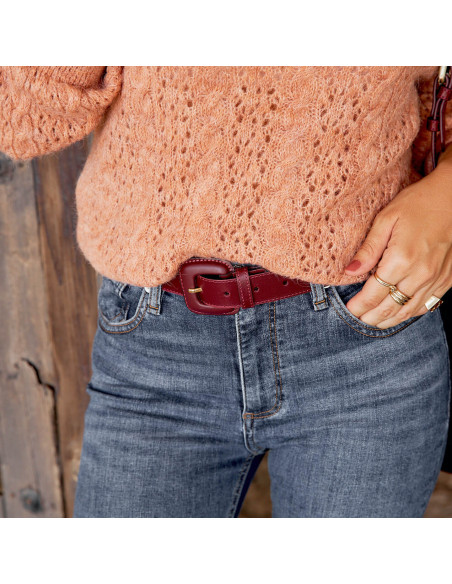 Women’s leather belt with covered buckle in burgundy color, styled with jeans and a pink sweater - MONPIEL Women’s leather belt with covered buckle in burgundy color, styled with jeans and a pink sweater - MONPIEL