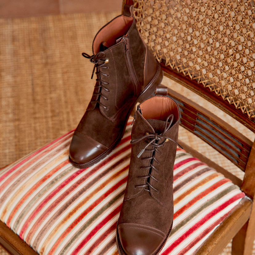 Women’s leather lace-up ankle boots in brown color, angled view on a chair - MONPIEL