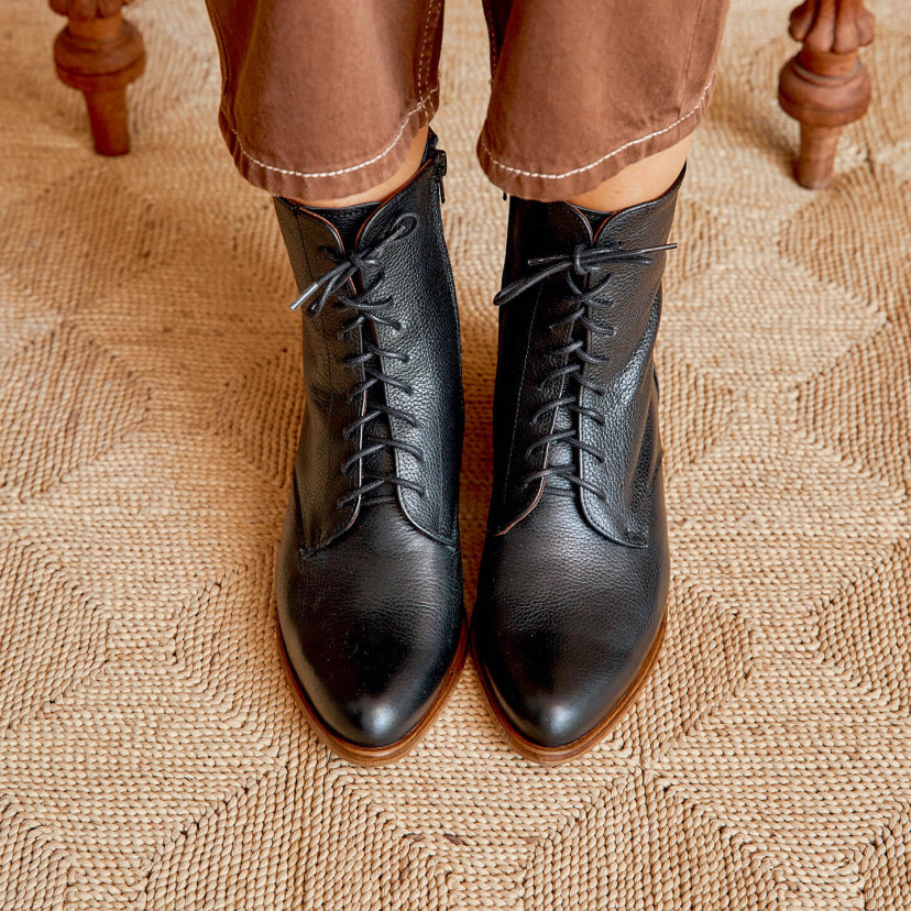 Women’s leather pointed-toe ankle boots in black color, front view, on a rug - MONPIEL