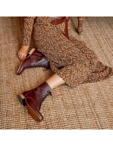 Women’s pointed-toe leather ankle boot in burgundy, top-down view, boot profile on a carpet - MONPIEL Women’s pointed-toe leather ankle boot in burgundy, top-down view, boot profile on a carpet - MONPIEL