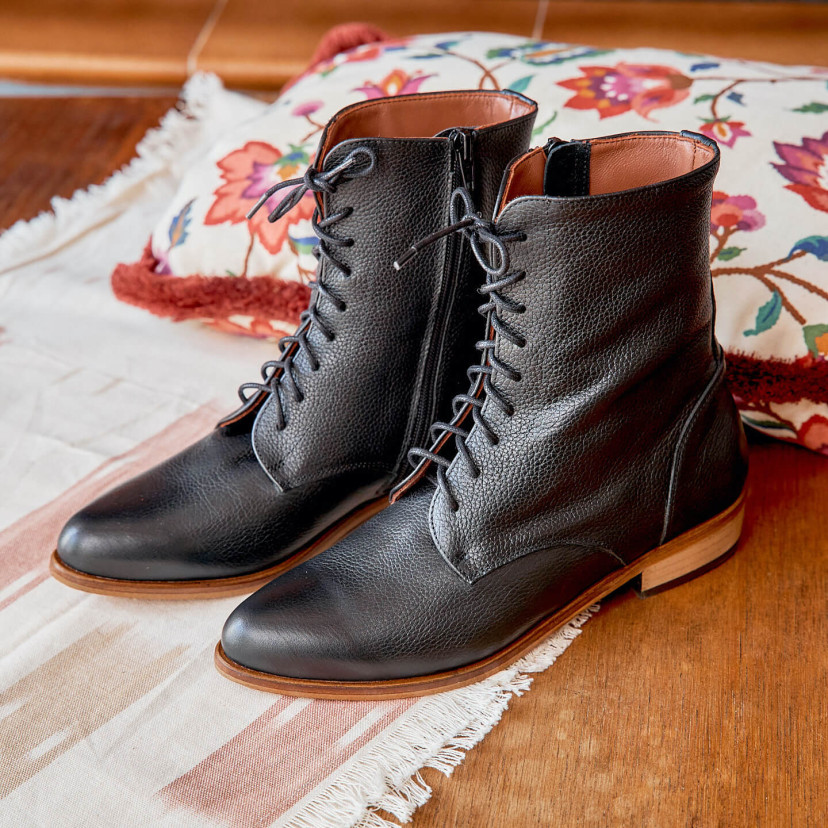 Women’s leather pointed-toe ankle boots in black color, angled view, on a rug - MONPIEL