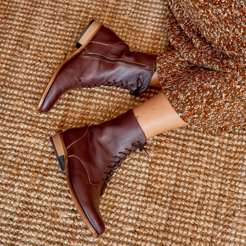 Women’s leather pointed-toe ankle boots in burgundy color, top view, boot profile on the floor - MONPIEL