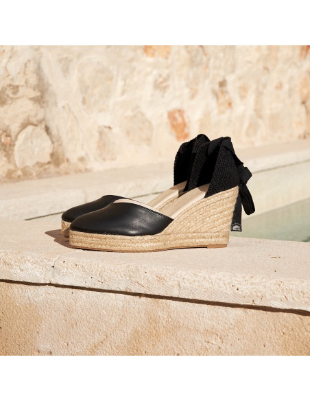 Espadrille com cunha Elba de couro preto com vista de perfil colocada na borda da piscina - MONPIEL Espadrille com cunha Elba de couro preto com vista de perfil colocada na borda da piscina - MONPIEL