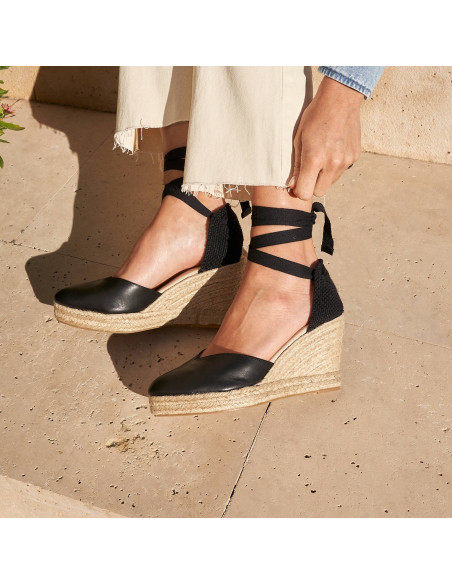 Espadrille à talon compensé Elba en cuir noir, vue de profil, pieds posés inclinés au sol - MONPIEL