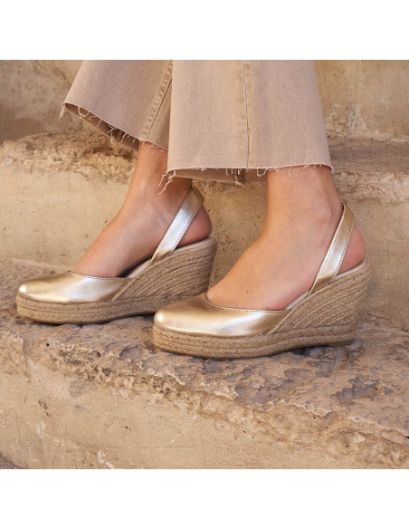 Platinum leather wedge espadrille, side view on an outdoor step - MONPIEL Platinum leather wedge espadrille, side view on an outdoor step - MONPIEL
