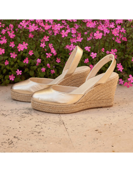 Espadrille à talon compensé en cuir platine, vue de profil avec un fond de fleurs - MONPIEL